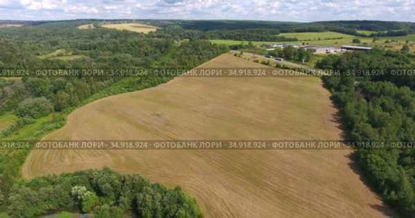 Aerial view at landscape with federal highway in the middle part of Russia. Green forests with agricultural fields. Стоковое видео, видеограф Кекяляйнен Андрей / Фотобанк Лори