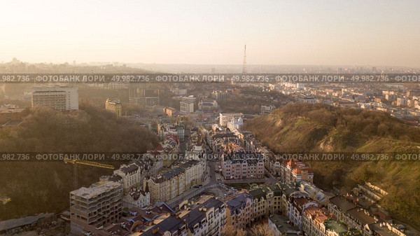 Aerial view from the drone, bird’s eye view to the Vozdvizhenka with newly built buildings, Andreevsky descent, tower Kyiv TV Center and other old houses.. A bird’s eye view, aerial view shooting from drone of the Podol district, oldest historical center of Kiev, Ukraine. Стоковое фото, агентство Ingram Publishing / Фотобанк Лори