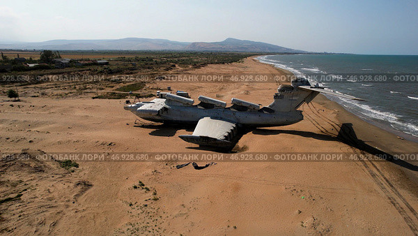 Aerial view of a ruined abandoned airplane found in an uninhabited island near the sea on blue sky background. Стоковое фото, фотограф David Kashakhi / Фотобанк Лори