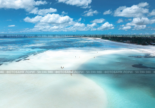 Aerial view of island during low tide, sandbank in ocean, white sandy beach, people, blue sea on sunny summer day in Zanzibar. Top view of sand spit, clear water, sky with clouds. Tropical background. Стоковое фото, агентство Ingram Publishing / Фотобанк Лори
