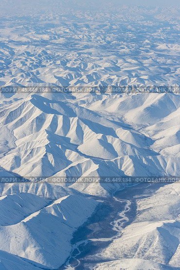 Aerial view of snow-capped mountains. Winter snowy mountain landscape. Air travel to the far North of Russia. Nuh River and Mount Nuh, Kolyma Mountains, Magadan Region, Siberia, Russian Far East. Стоковое фото, фотограф Андрей Степанов / Фотобанк Лори