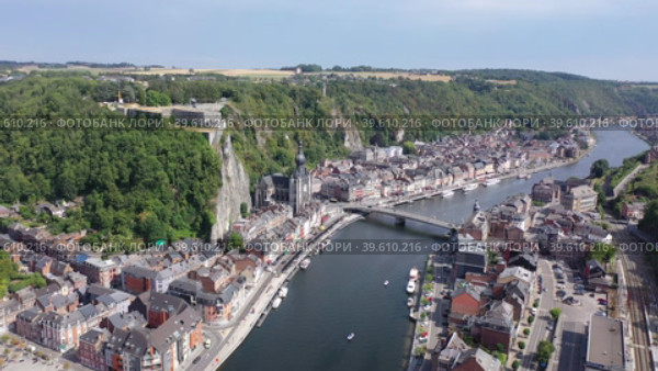 Aerial view of Walloon city of Dinant located along Meuse river with Gothic medieval Collegiate Church of Our Lady and fortified castle perched atop green vertical cliff in summer, Belgium. Стоковое видео, видеограф Яков Филимонов / Фотобанк Лори