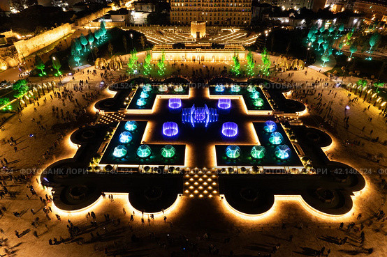 Aerial view to largest light and music fountain in Russia. 2214 colours jets burst into sky with musical accompaniment. Night show fire on the water in Nizami Ganjavi Park Derbent, Dagestan, Europe. Стоковое фото, фотограф Алексей Ширманов / Фотобанк Лори