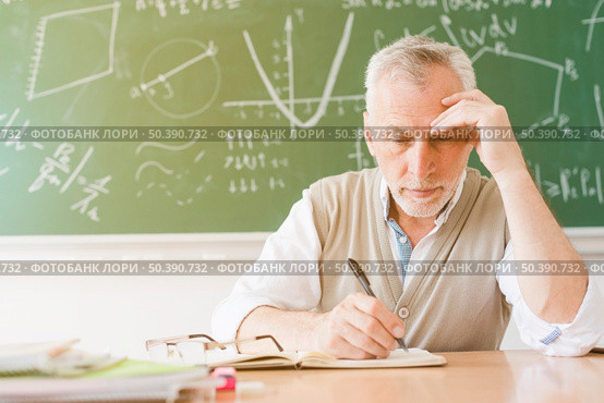 aged tired teacher writing notebook classroom. Стоковое фото, агентство Ingram Publishing / Фотобанк Лори
