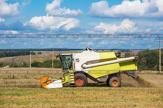 Agricultural industry. A combine harvester harvests from the field. The concept of processing and collection . Rural landscape. Agricultural machinery. Стоковое фото, фотограф Photojuli / Фотобанк Лори