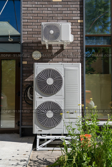 Air conditioning system assembled on side of building. External cooling system units unit compressor install outside. Condensing unit for removing heat and moisture from indoor. Стоковое фото, фотограф Данила Большаков / Фотобанк Лори