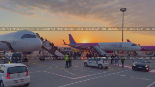 Aircraft boarding at sunset with passengers preparing for flight. Редакционное видео, видеограф Антон Гвоздиков / Фотобанк Лори