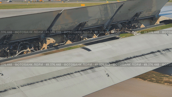 Airplane wing spoilers extending during landing approach. Стоковое фото, фотограф Mikhail Davidovich / Фотобанк Лори