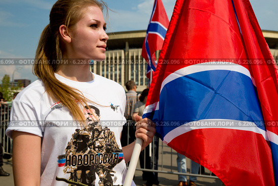 Активистка НОД - Мария держит флаг Новороссии на митинге в поддержку Донбасса, Новороссии под названием "Битва за Донецкую Русь!", 2 августа 2014. Редакционное фото, фотограф Николай Винокуров / Фотобанк Лори