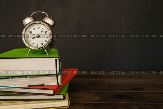 alarm clock with books pile desk. Стоковое фото, агентство Ingram Publishing / Фотобанк Лори
