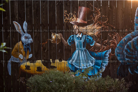 Alice in Wonderland is a work by Lewis Carroll. Fabulous illustration on the wall. It's a beautiful drawing. Art and art. Редакционное фото, фотограф Photojuli / Фотобанк Лори
