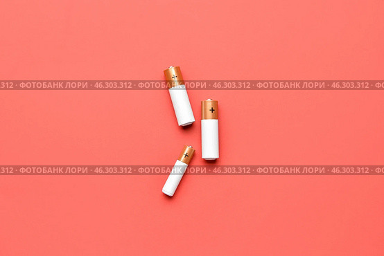 Alkaline batteries on red background, top view. Стоковое фото, фотограф Pixel_shot / Фотобанк Лори