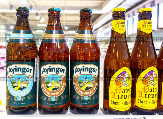 Алкогольное пиво Ayinger готово к продаже на полке в супермаркете. Различные бутилированные алкогольные напитки. Редакционное фото, фотограф FotograFF / Фотобанк Лори