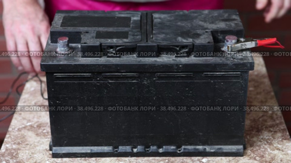 Alligator clips of charger are connected to contacts of car battery. Стоковое видео, видеограф Владимир Григорьев / Фотобанк Лори