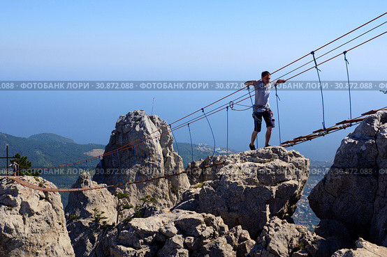 Алупка, Крым - 21 сентября 2018. Подвесная лестница на горе Ай-Петри. Туристы идут по висящей лестнице между зубцами горы. Редакционное фото, фотограф ирина реброва / Фотобанк Лори