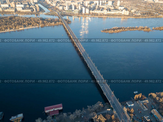 Amazing cityscape on the left bank of the Dnieper, modern construction and Patona bridge on a sunny summer day in Kiev, Ukraine. Aerial photography from flying drone. Aerial view from the drone to the Patona Bridge, Dnieper River in the city of Kiev, Ukraine. Стоковое фото, агентство Ingram Publishing / Фотобанк Лори