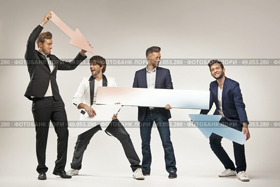 Amused guys holding arrows and boards. Стоковое фото, агентство Ingram Publishing / Фотобанк Лори