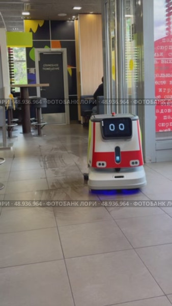 An autonomous cleaning robot moving across the shiny floor of the Vkusno i Tochka restaurant, emphasizing its modern technologies, Vkusno i tochka, Russia, Moscow, 05.05.2025. Редакционное видео, видеограф Терехова Марина / Фотобанк Лори