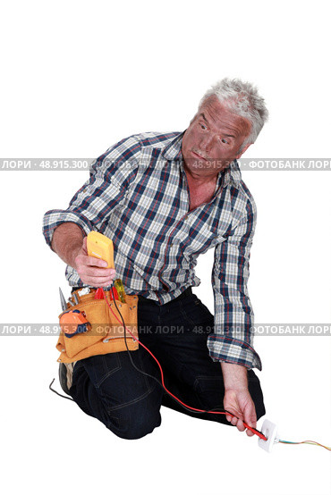 An electrocuted tradesman staring at his multimeter. Стоковое фото, агентство Ingram Publishing / Фотобанк Лори