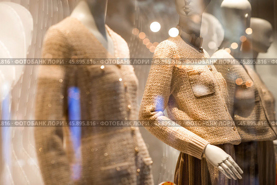 An elegant showcase of an expensive luxury store with stylish mannequins in clothes and evening lighting. The concept of shopping and sales. Стоковое фото, фотограф Photojuli / Фотобанк Лори
