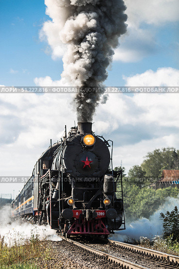 An old Soviet steam locomotive of the L series. The Ruskeala Express retro train is on its way to the mountain park. Thick smoke is coming from the chimney. Russia, Republic of Karelia, Sortavala, August 10, 2025. Редакционное фото, фотограф Photojuli / Фотобанк Лори