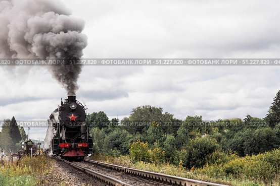 An old Soviet steam locomotive of the L series. The Ruskeala Express retro train is on its way to the mountain park. Thick smoke is coming from the chimney. Russia, Republic of Karelia, Sortavala, August 11, 2025. Редакционное фото, фотограф Photojuli / Фотобанк Лори