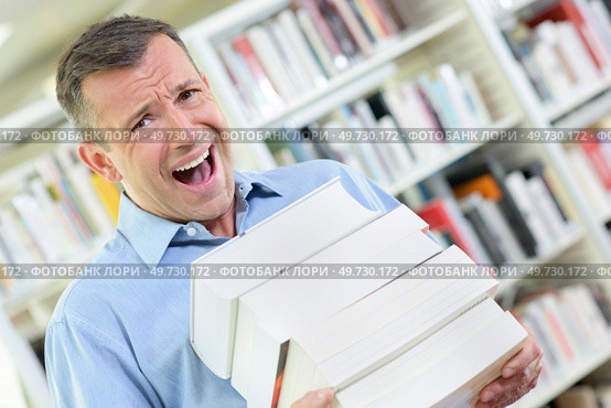 an upset man with books. Стоковое фото, агентство Ingram Publishing / Фотобанк Лори