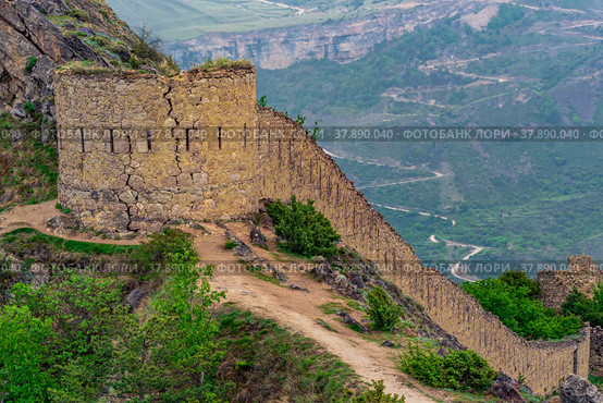 Ancient tower and castle wall on top of a sheer cliff in a mountainous area, Shamil (Gunib) fortress in Dagestan, Стоковое фото, фотограф Евгений Харитонов / Фотобанк Лори