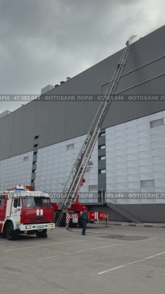 ANGARSK, IRKUTSK REGION, RUSSIA- April 08, 2025: Vertical video of firefighters climb an extension ladder to roof of building. Work of Russian Emergencies Ministry. Preventive training of firefighters. Редакционное видео, видеограф Виктория Катьянова / Фотобанк Лори