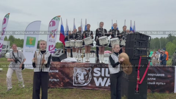 ANGARSK, IRKUTSK REGION, RUSSIA - July 13, 2025: XV International Silk Way Rally, racing competition.Video of group of beautiful drummers girls perform on open stage before start of motor rally on rainy day. Редакционное видео, видеограф Виктория Катьянова / Фотобанк Лори