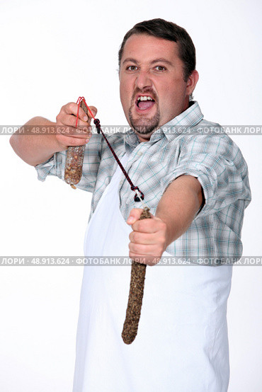 Angry butcher fighting with sausages. Стоковое фото, агентство Ingram Publishing / Фотобанк Лори