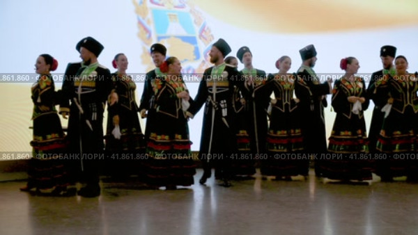 Ансамбль народной песни и пляски выступает на сцене на фоне развевающегося флага Ставропольского края в городе Москве, Россия (2023 год). Редакционное видео, видеограф Николай Винокуров / Фотобанк Лори
