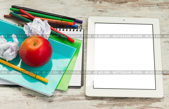 Apple with school supplies and tablet with empty screen on white wooden table, top view. Apple with school supplies. Стоковое фото, агентство Ingram Publishing / Фотобанк Лори