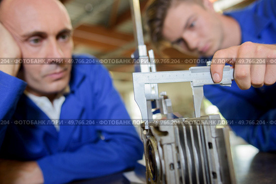 Apprentice measuring a cylinder with a vernier guage. Стоковое фото, агентство Ingram Publishing / Фотобанк Лори