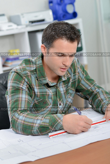 Architect sat drawing at his desk. Стоковое фото, агентство Ingram Publishing / Фотобанк Лори