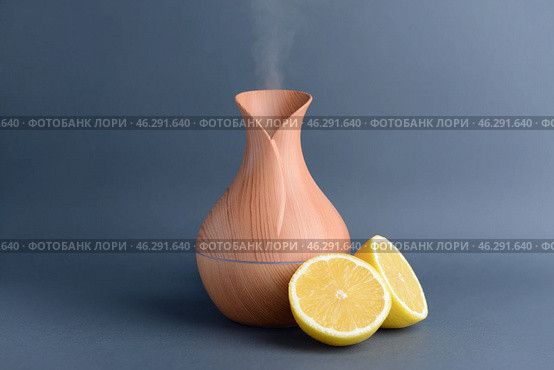 Aroma oil diffuser and citrus fruit on grey background. Стоковое фото, фотограф Pixel_shot / Фотобанк Лори