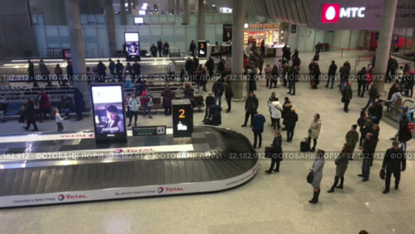 Arrived passengers are expected luggage in baggage delivery zone. Arrival lounge of the Pulkovo International airport. It serves citizens of St. Petersburg city (2019 год). Редакционное видео, видеограф Кекяляйнен Андрей / Фотобанк Лори