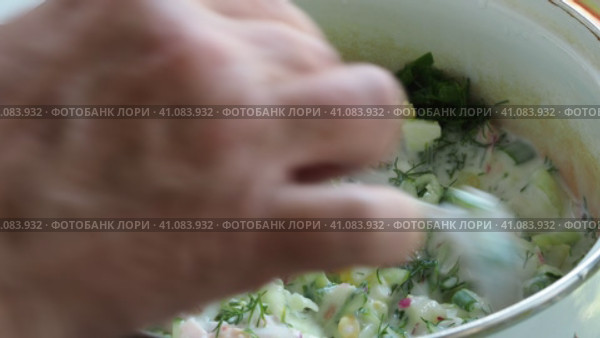 Asian cuisine, cooking simple food (okroshka). The cook pours a milk drink into a pot of vegetables and stirs it with a spoon . Стоковое видео, видеограф Сергей Медведев / Фотобанк Лори