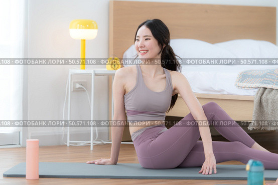 Asian young women doing yoga exercises during their holiday at home. Стоковое фото, агентство Ingram Publishing / Фотобанк Лори