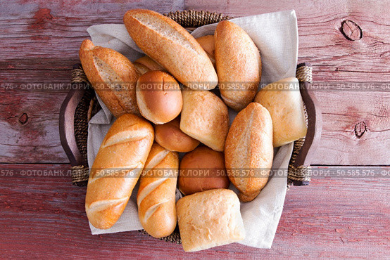 Assorted crusty fresh golden bread rolls in a basket in different speciality shapes displayed on a rustic wooden buffet table as an accompaniment to a meal. Assorted crusty fresh bread rolls in a basket. Стоковое фото, агентство Ingram Publishing / Фотобанк Лори