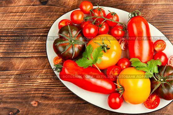 Assorted heirloom tomatoes on a rustic wooden table. Ripe tomatoes on rustic wooden background. Стоковое фото, агентство Ingram Publishing / Фотобанк Лори