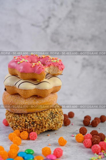 Assorted stack donuts and strawberry bitten donuts placed on top. Стоковое фото, агентство Ingram Publishing / Фотобанк Лори