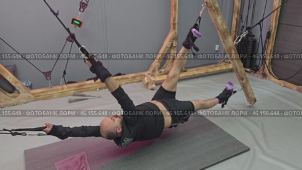 Athlete performing suspension training exercises in gym. Стоковое видео, видеограф Юрий Поздников / Фотобанк Лори