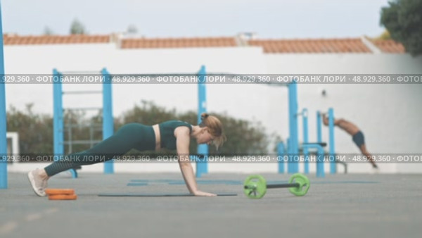 Athletic woman doing push ups on the outdoors. Стоковое видео, видеограф Константин Шишкин / Фотобанк Лори