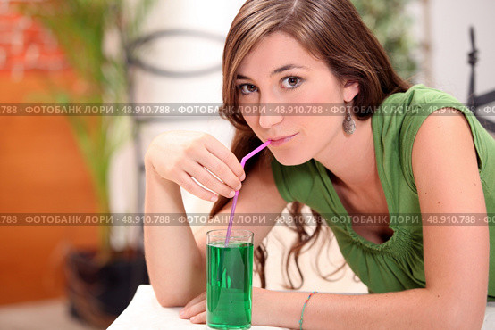 Attractive brunette drinking mint cordial. Стоковое фото, агентство Ingram Publishing / Фотобанк Лори
