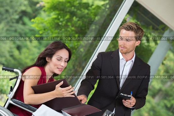 attractive disabled woman ordering to the waiter at the restaurant. Стоковое фото, агентство Ingram Publishing / Фотобанк Лори