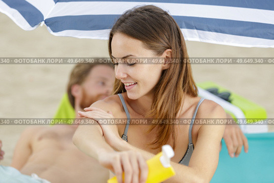 attractive young woman with healthy skin applying suncream. Стоковое фото, агентство Ingram Publishing / Фотобанк Лори