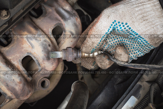 Auto mechanic pulled oxygen sensor or lambda probe for diagnostics at car service station. Стоковое фото, фотограф Сергей Чайко / Фотобанк Лори