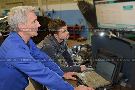 auto mechanic teacher and trainee performing tests at mechanic school. Стоковое фото, агентство Ingram Publishing / Фотобанк Лори