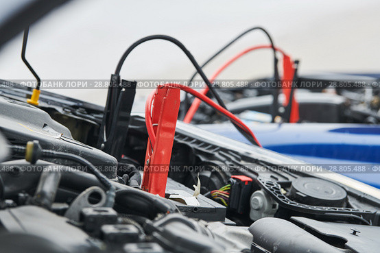 Automobile help. booster jumper cables charging automobile discharged battery. Стоковое фото, фотограф Дмитрий Калиновский / Фотобанк Лори